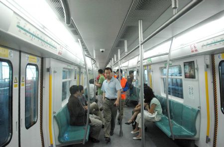 People take a train of Beijing Subway Line 4 in Beijing, capital of China, on May 31, 2009. Beijing Subway Line 4 of about 28 kilometers began test operation on May 31. It will be put into use at the end of September. 