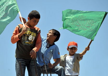 Photo taken on May 29, 2009 shows Palestinian boys wave flags of supporting Hamas in the West Bank city of Hebron. 