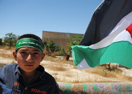 Photo taken on May 29, 2009 shows a Palestinian boy with a sign of supporting Hamas on his head in the West Bank city of Hebron.