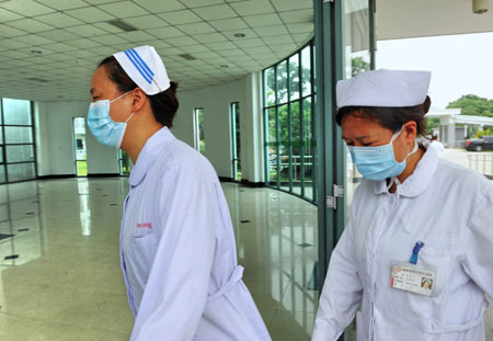 Medical workers walk into the quarantine zone of the Fuzhou Pulmonary Hospital in Fuzhou, capital of southeast China's Fujian Province, on June 1, 2009. The number of confirmed A/H1N1 flu cases in Fujian has risen to six as two new A/H1N1 flu cases were confirmed on Monday.