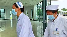 Medical workers walk into the quarantine zone of the Fuzhou Pulmonary Hospital in Fuzhou, capital of southeast China's Fujian Province, on June 1, 2009. The number of confirmed A/H1N1 flu cases in Fujian has risen to six as two new A/H1N1 flu cases were confirmed on Monday.