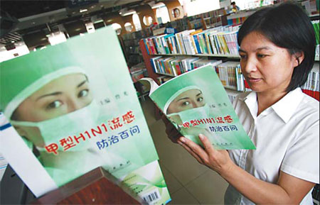 A woman glances through a book about A(H1N1) flu at a bookstore in Weifang, Shandong Province, on Wednesday. 