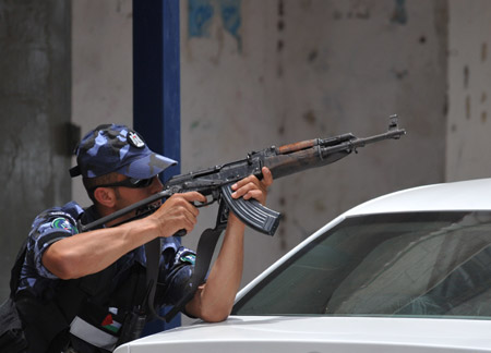 A Palestinian policeman takes position at the scene of the gunbattle in the northern West Bank city of Qalqilya on June 4, 2009.