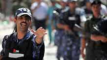 A Palestinian policeman dispels residents near the scene of the gunbattle in the northern West Bank city of Qalqilya on June 4, 2009. Three Hamas militants and a Palestinian policeman were killed in gunbattles between Hamas militants and Palestinian security forces in Qalqilya on Thursday.