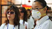 A quarantine official (R) guides passengers for temperature examination at the Maweigang dock in Fuzhou, capital of east China's Fujian Province, on May 30, 2009.