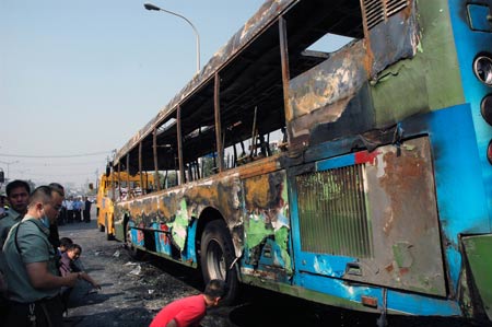 Firefighers and policemen investigate at the spot of a fire broke out on a public bus in Chengdu, capital of southwest China's Sichuan Province, on June 5, 2009. 