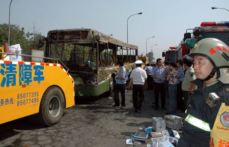 Firefighers work at the spot of a fire broke out on a public bus in Chengdu, capital of southwest China&apos;s Sichuan Province, on June 5, 2009. 