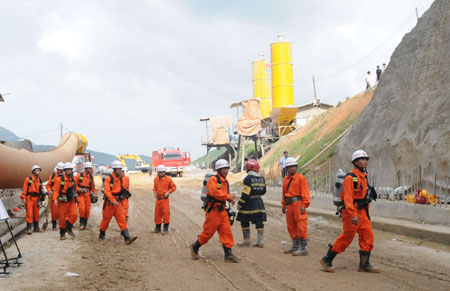 Rescuers walk to the collapsed Yingbin Tunnel on the expressway circling Sanya City, south China's Hanan Province, June 5, 2009. At least eight workers have been trapped for more than nine hours after a tunnel under construction collapsed here, the tunnel constructor said Friday.