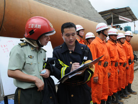 Rescuers prepare to get into the collapsed Yingbin Tunnel on the expressway circling Sanya City, south China's Hanan Province, June 5, 2009. At least eight workers have been trapped for more than nine hours after a tunnel under construction collapsed here, the tunnel constructor said Friday.