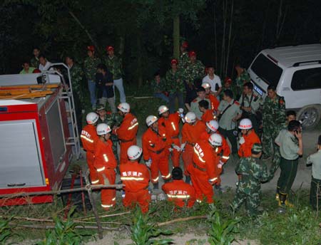 A team of fire fighters await orders before rescue near the site of landslide at an iron ore mining area in southwest China's Chongqing Municipality, southwest China, June 5, 2009.At least 80 people are feared buried in the landslide in Chongqing on Friday, according to the local government. Rescuers had pulled out seven injured people, including four seriously hurt, from the debris as of 8:30 p.m., according to the publicity department of Wulong County, the site of the accident. 