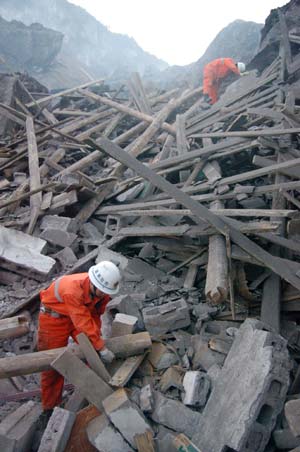 Firemen search for survivors at the site where a landslide occured earlier in the Jiwei Mountain area, in Tiekuang Township, about 170 kilometers southeast of the downtown area, southwest China's Chongqing Municipality, June 5, 2009. At least 80 people were feared buried in the landslide at an iron ore mining area in Chongqing Municipality on Friday, according to the local government.