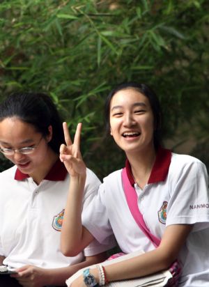 A student gestures at an exam site prior to the college entrance exam in east China's Shanghai, on June 7, 2009. China's national college entrance exam kicked off on Sunday with about 10.2 million registered examinees.