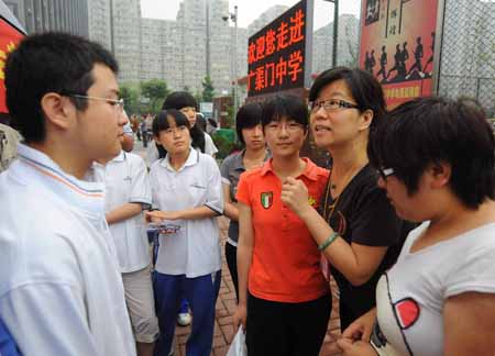 Students talk with their teacher at an exam site prior to the college entrance exam in Beijing, capital of China, June 7, 2009. China's national college entrance exam kicked off on Sunday with about 10.2 million registered examinees.