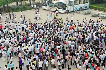 Students wait outside an exam site prior to the college entrance exam in Songxian County of center China's Henan Province, June 7, 2009. China's national college entrance exam kicked off on Sunday with about 10.2 million registered examinees.