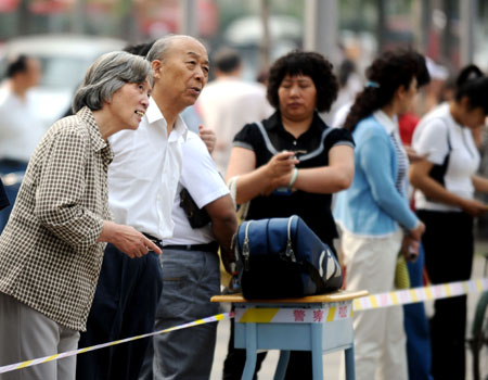 Relatives wait outside an exam site during the college entrance exam in Taiyuan, capital of north China's Shanxi Province, June 7, 2009. China's national college entrance exam kicked off on Sunday with about 10.2 million registered examinees.