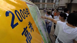 Students wait in an exam site of a middle school to attend the college entrance exam in Haikou, capital of south China's Hainan Province, on June 7, 2009. China's national college entrance exam kicked off on Sunday with about 10.2 million registered examinees.