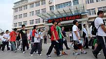 Students walk to an exam site of a middle school for the college entrance exam in Qingdao, east China's Shandong Province, on June 7, 2009. China's national college entrance exam kicked off on Sunday with about 10.2 million registered examinees.