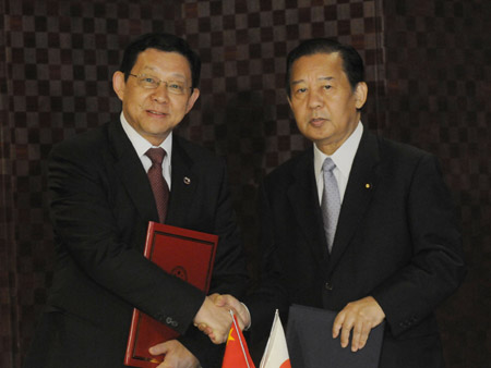 Chinese Commerce Minister Chen Deming(L) exchanges documents with his Japanese counterpart Toshihiro Nikai in Tokyo, Japan, on June 7, 2009. Chen Deming and Toshihiro Nikai exchanged views on various economic and trade issues and reached broad consensus on future cooperation. 