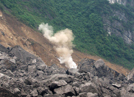 The second blasting is carried out at around 1:00 PM  to enable the drilling of a hole 40 meters deep to send food and air to 27 trapped miners who could still be alive after Friday's massive landslide in Wulong County of southwest China's Chongqing, on June 7, 2009.