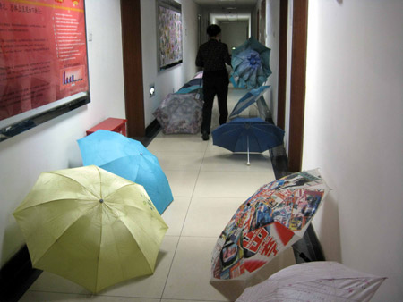 A working staff pass by umbrellas in a building in Beijing, on June 8, 2009. 