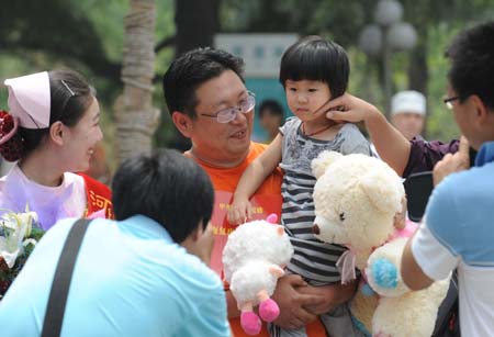 The first confirmed A/H1N1 flu patient in Henan Province (R1) prepares to leave the hospital in Zhengzhou, capital of central China's Henan Province, on June 9, 2009. The 3-year-old girl was discharged from hospital on Tuesday. She arrived in Zhengzhou on May 29 from the United States and was confirmed as the first A/H1N1 case in Henan on June 1.