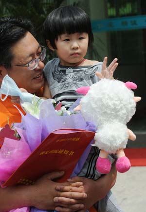 The first confirmed A/H1N1 flu patient in Henan Province (R) prepares to leave the hospital in Zhengzhou, capital of central China's Henan Province, on June 9, 2009. The 3-year-old girl was discharged from hospital on Tuesday. She arrived in Zhengzhou on May 29 from the United States and was confirmed as the first A/H1N1 case in Henan on June 1.