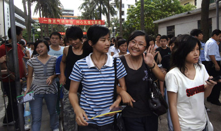 Students walk out after finishing their college entrance exam at the Haikou No.1 Middle School in Haikou, capital of south China's Hainan Province, June 9, 2009. The national college entrance examination, or 'gaokao' in Chinese, was finished in most regions of China on June 8. Students in Shanghai and Shandong finished the exam at noon of June 9 and students in Jiangsu, Guangdong and Hainan finished it in the afternoon. 