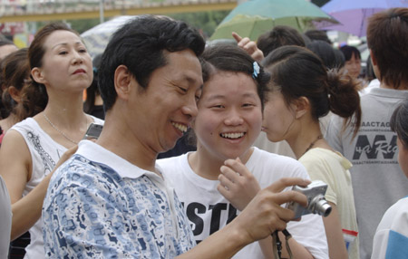 A student and her relative share a light moment after finishing the college entrance exam at a middle school in Haikou, capital of south China's Hainan Province, on June 9, 2009.