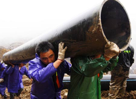 Rescue workers lay water pipes to release a barrier lake caused by a massive landslide at Jiwei Mountain, in Wulong County of southwest China's Chongqing Municipality, on June 9, 2009. The local government has relocated villagers threatened by the lake which increased to more than 10,000 steres due to continuous rainfall.