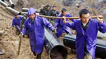 Rescue workers lay water pipes to release a barrier lake caused by a massive landslide at Jiwei Mountain, in Wulong County of southwest China's Chongqing Municipality, on June 9, 2009. The local government has relocated villagers threatened by the lake which increased to more than 10,000 steres due to continuous rainfall.