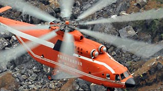 A MI-26 helicopter hovers to unload an excavator at the landslide site of Jiwei Mountain, in Wulong County, southwest China's Chongqing Municipality, on June 11, 2009. The MI-26 heavy-lifting helicopter has begun carrying heavy machineries needed in the search for 63 people missing in a massive landslide on Friday. The heavy machineries will be used to remove giant rocks that buried two entrances to an iron ore mine, where 27 miners are believed to be trapped.