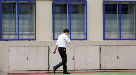 A teacher walks in the private Seisoku High School in Tokyo, capital of Japan, on June 12, 2009. The first A/H1N1 flu group infections in Tokyo were confirmed on Thursday, with nine students and three teachers of the high school in Minato Ward contracting the disease. The high school will be closed for one week from Thursday due to the outbreak.