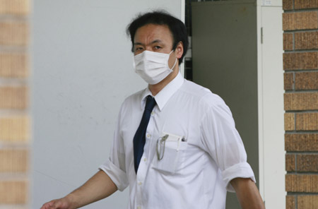 A teacher walks in the private Seisoku High School in Tokyo, capital of Japan, on June 12, 2009. The first A/H1N1 flu group infections in Tokyo were confirmed on Thursday, with nine students and three teachers of the high school in Minato Ward contracting the disease. The high school will be closed for one week from Thursday due to the outbreak. 