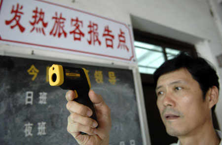 A worker tests a temperature monitor in the Xingang dock in Haikou, capital of south China's Hainan Province, June 13, 2009. Hainan confirmed its first A/H1N1 flu case, a female college student, on Friday night.