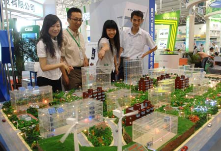Visitors are attracted by a model of comprehensive new energy source utilizing system at the China International Energy Saving and Environmental Protection Exhibition 2009 in Beijing, capital of China, on June 14, 2009. The exhibition kicked off on Sunday and attracted over 250 enterprises from home and abroad. 