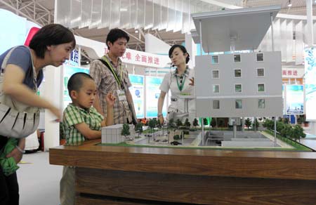 Visitors are attracted by a model of energy saving building at the China International Energy Saving and Environmental Protection Exhibition 2009 in Beijing, capital of China, on June 14, 2009. The exhibition kicked off on Sunday and attracted over 250 enterprises from home and abroad.