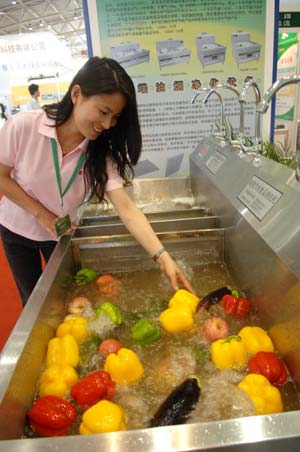 A worker shows a highly-efficient food cleaning system at the China International Energy Saving and Environmental Protection Exhibition 2009 in Beijing, capital of China, on June 14, 2009. The exhibition kicked off on Sunday and attracted over 250 enterprises from home and abroad. 