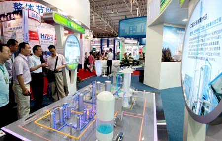 Visitors view a model of a carbon dioxide collecting system of a power plant at the China International Energy Saving and Environmental Protection Exhibition 2009 in Beijing, capital of China, on June 14, 2009. The exhibition kicked off on Sunday and attracted over 250 enterprises from home and abroad. 