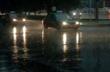 Taxis are seen in the heavy rain in Beijing, China, on June 16, 2009. Local authority released a yellow alert for lightings on Tuesday.