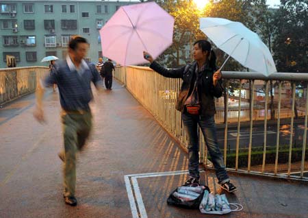 A vendor sells umbrellas in the rain in Beijing, China, on June 16, 2009. Local authority released a yellow alert for lightings on Tuesday. 