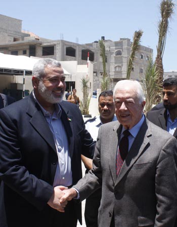 Former US President Jimmy Carter (R) shakes hands with the deposed Hamas Prime Minister Ismail Haneya in Gaza City, on June 16, 2009. 