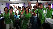 Students of Sangping Middle School of Wenchuan County, southwest China's Sichuan Province, wave goodbye to people seeing them off at the Guangzhou Railway Station in Guangzhou, capital of south China's Guangdong Province, on June 17, 2009.