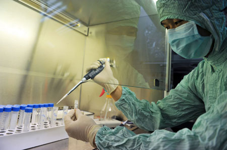 A researcher dilutes the virus strains of the influenza A/H1NI for cuvette cultivation of its vaccination at a lab of the Wuhan Institute of Biological Products in Wuhan, central China's Hubei Province, on June 17, 2009. A total of 6 virus strains of the influenza A/H1NI supplied by the World Health Organization (WHO) were delivered here and started for their proliferated cultivation in the morning. 