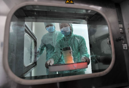 The researchers pass the container with virus strains of the influenza A/H1NI for cultivation of its vaccination through an obturator onto laboratory at the other side at the Wuhan Institute of Biological Products in Wuhan, central China's Hubei Province, on June 17, 2009.