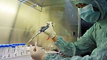 A researcher dilutes the virus strains of the influenza A/H1NI for cuvette cultivation of its vaccination at a lab of the Wuhan Institute of Biological Products in Wuhan, central China's Hubei Province, on June 17, 2009. A total of 6 virus strains of the influenza A/H1NI supplied by the World Health Organization (WHO) were delivered here and started for their proliferated cultivation in the morning.