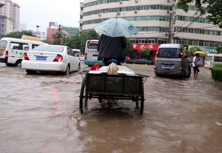 Vehicles move on a flooded street in Xi&apos;an, capital of northwest China&apos;s Shaanxi Province, on June 19, 2009. Heavy rain has been striking some cities and counties in Shaanxi Province since June 18.