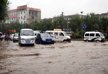 Vehicles move on a flooded street in Xi&apos;an, capital of northwest China&apos;s Shaanxi Province, on June 19, 2009. Heavy rain has been striking some cities and counties in Shaanxi Province since June 18.