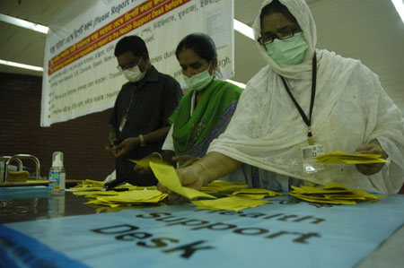 Health workers sort out 'Self Declaration of A/H1N1 Flu Status' papers at Zia International Airport in Dhaka, capital of Bangladesh, on June 19, 2009. The first A/H1N1 flu case has been detected in Bangladesh, the country's health ministry said in a press release on Friday.