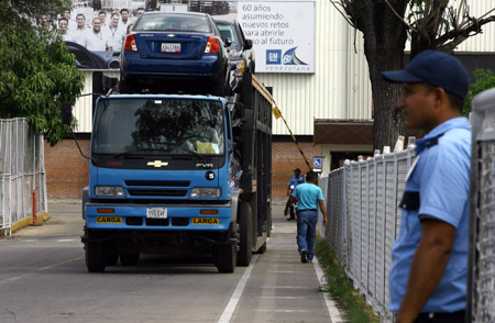 A truck loading new General Motor (GM) cars drives out of a GM assembly plant in Valencia, Venezuela, on June 19, 2009. The assembly plant was temporarily shut down for 3 months because it cannot import car parts timely. 