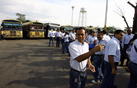 Workers of a General Motor (GM) assembly plant walk out of the factory to go home in Valencia, Venezuela, on June 19, 2009. The assembly plant was temporarily shut down for 3 months because it cannot import car parts timely.